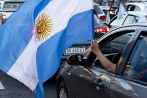 autos nuevos en concesionario con banderas argentinas