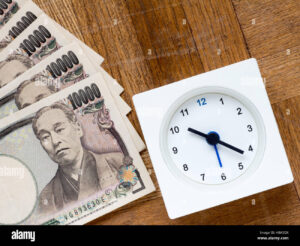 billetes y reloj sobre mesa madera