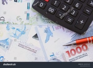 calculadora y billetes argentinos sobre escritorio 2
