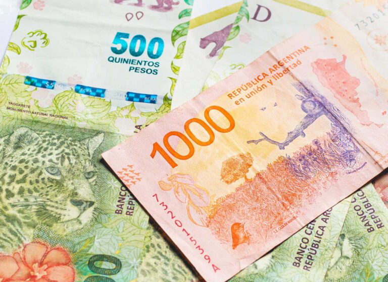 dos tarjetas de debito sobre billetes argentinos