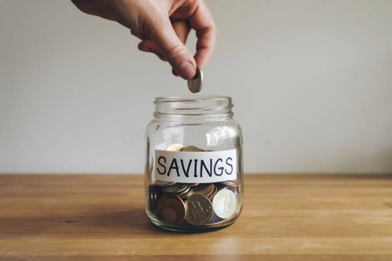 mano colocando monedas en frascos ahorros