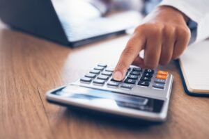 manos calculando finanzas con calculadora bancaria
