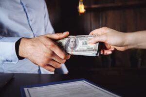 manos entregando dinero y documento legal