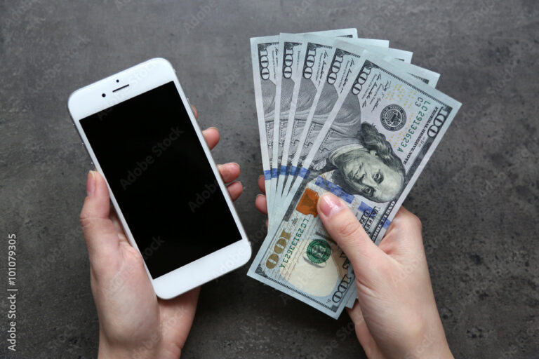 manos sosteniendo billetes y telefono movil