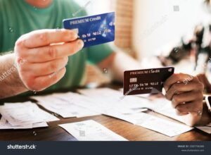 manos sosteniendo tarjeta bancaria y documento financiero