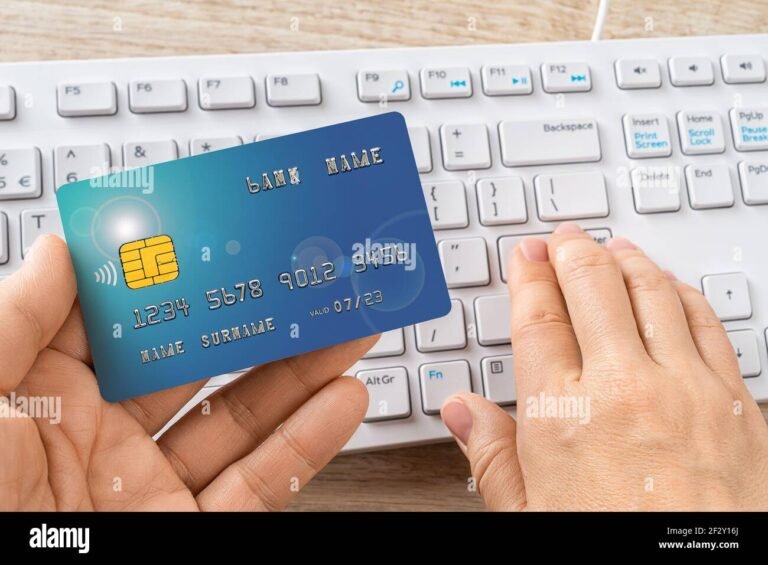manos sujetando tarjeta mastercard sobre teclado