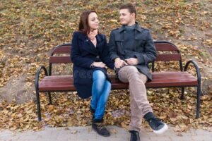 pareja conversando en un parque sonriente