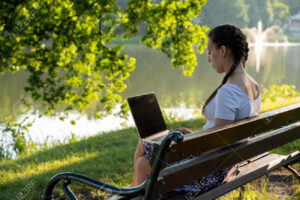 persona aprendiendo en computadora portatil outdoors