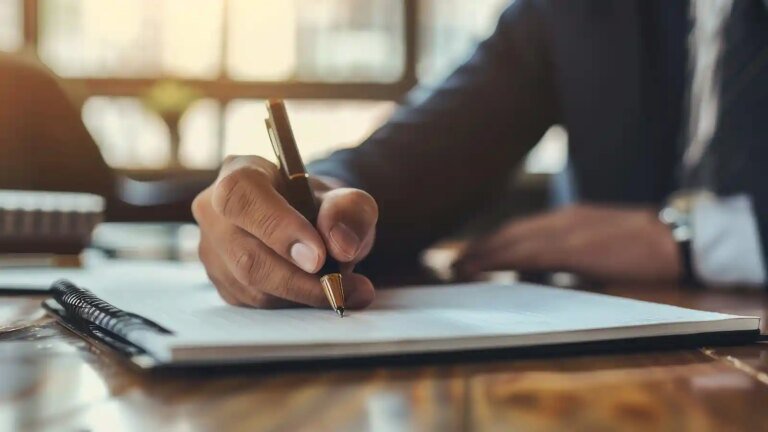 persona escribiendo carta formal en escritorio