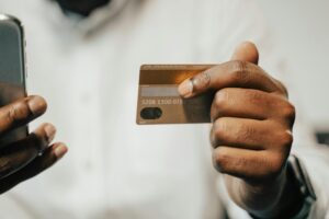 persona pagando con celular y tarjeta bancaria