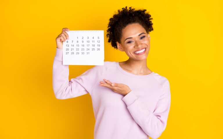 Cuándo y dónde puedo consultar el día de cobro de la asignación 2 persona revisando calendario con sonrisa