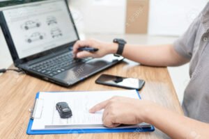 persona usando computadora con auto y documentos