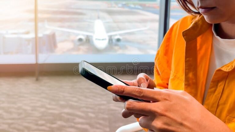 persona usando smartphone en aeropuerto moderno