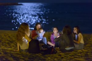 playa nocturna con luces y gente feliz