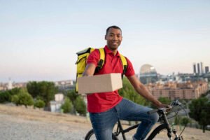 repartidor en bicicleta con paquete delivery