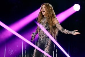 shakira cantando en un escenario iluminado